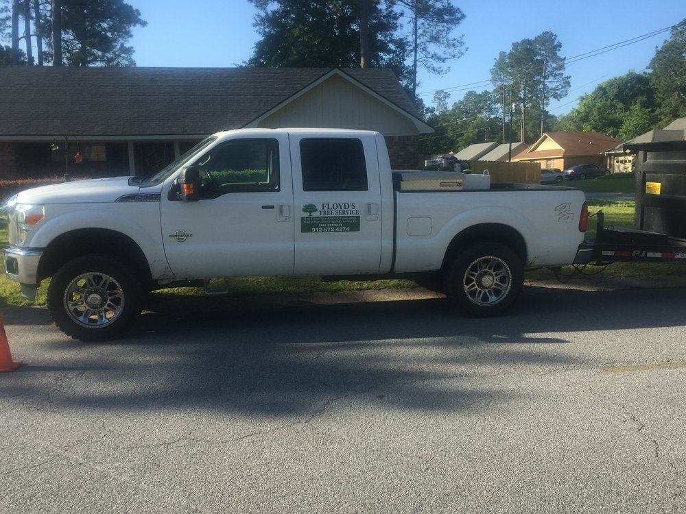 Floyd's Tree Service's white truck parked at a job site in Hinesville, GA